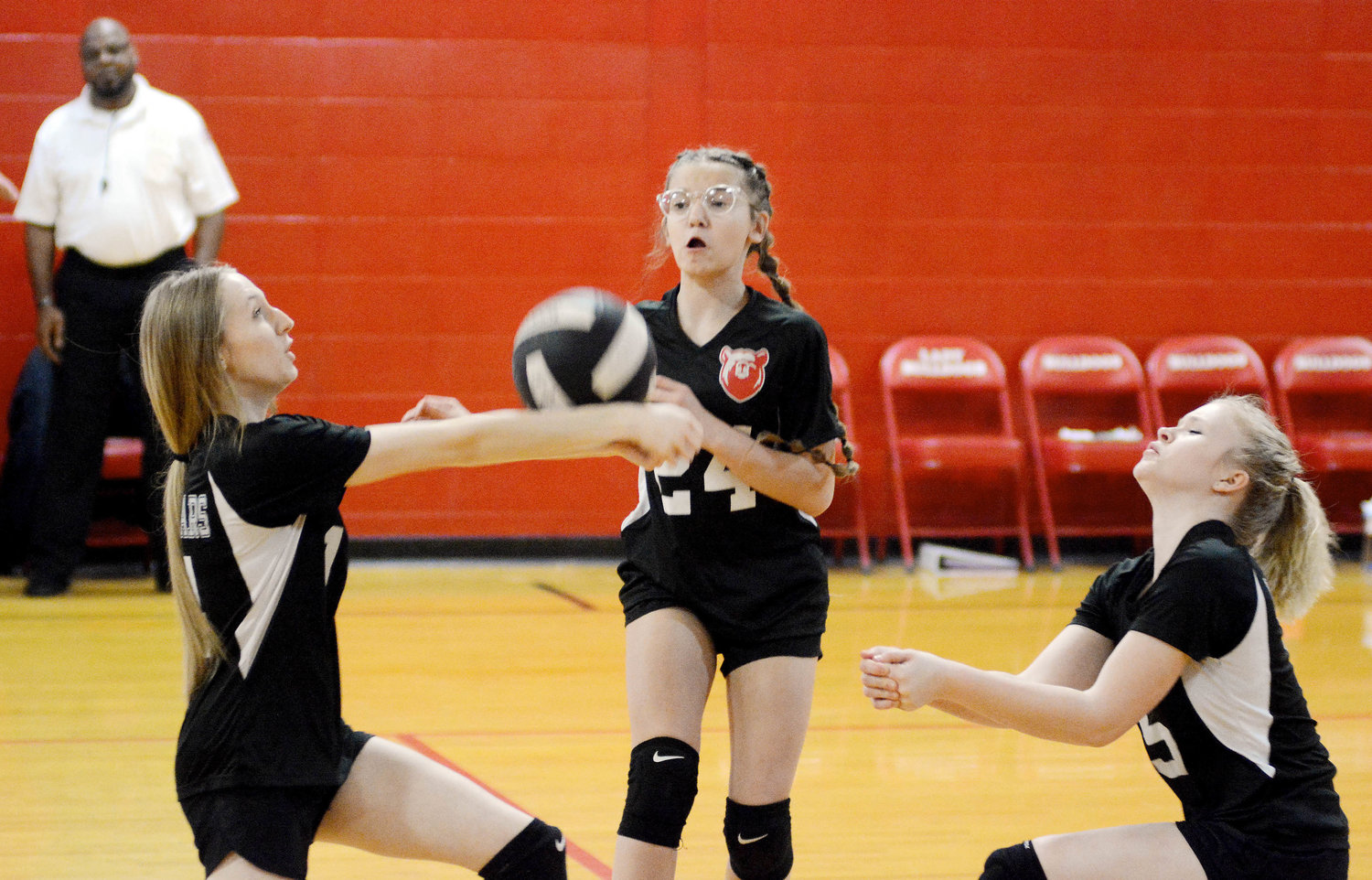 Cloie Schneider, Kyrie Rhoads and Lorraine Smith (from left) converge on a volleyball during warm ups prior to seventh-grade volleyball action Friday night at Dixon between the Bland Lady Bears and host Lady Bulldogs.